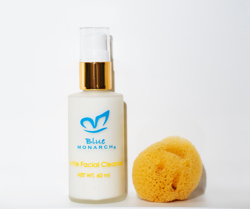 Product image of Blue Monarch Gentle Facial Cleanser, a 60 ml bottle with a golden pump, displayed alongside a natural sponge.